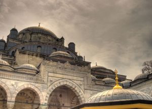 Mosque dome and arched courtyard under a dramatic cloudy sky