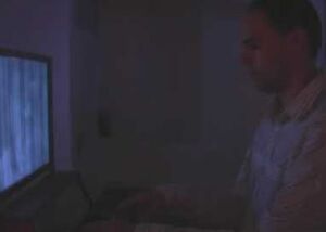 Still from a video of the Organ installation: a man seated at a keyboard in front of a glowing screen
