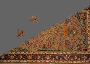Still from the video Woven Time: an ornate carpet cut into a triangle, with two small fragments floating on a grey background